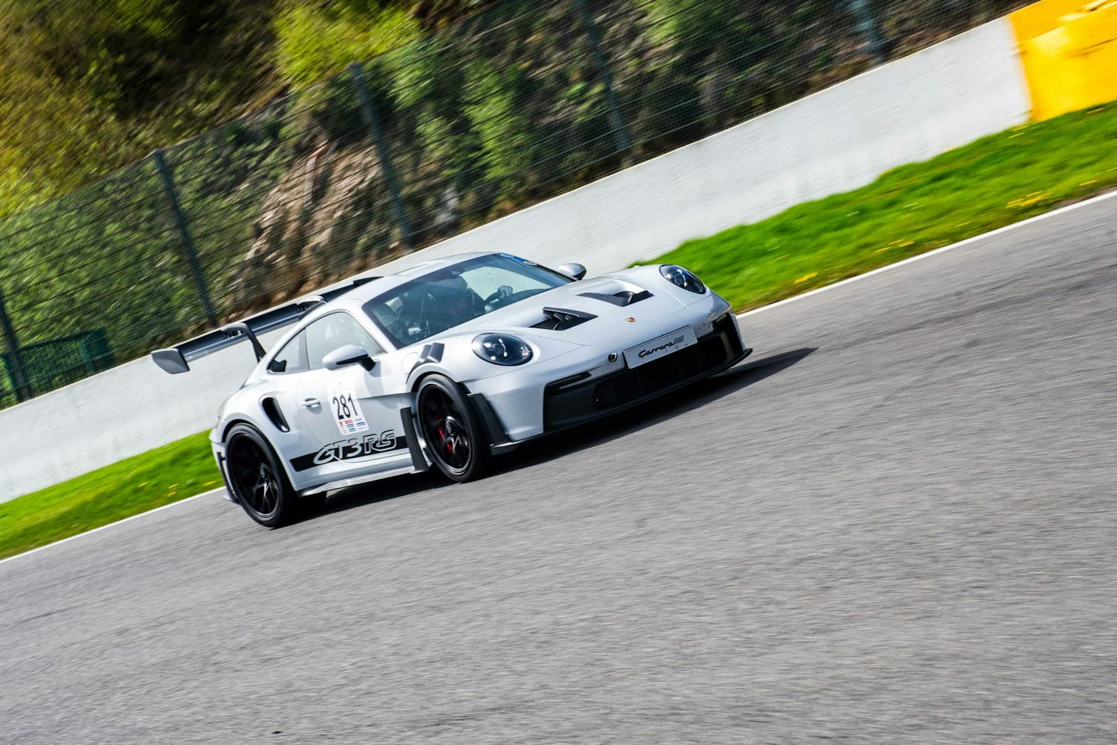 Porsche 911 GT3 RS cornering at speed on a race circuit